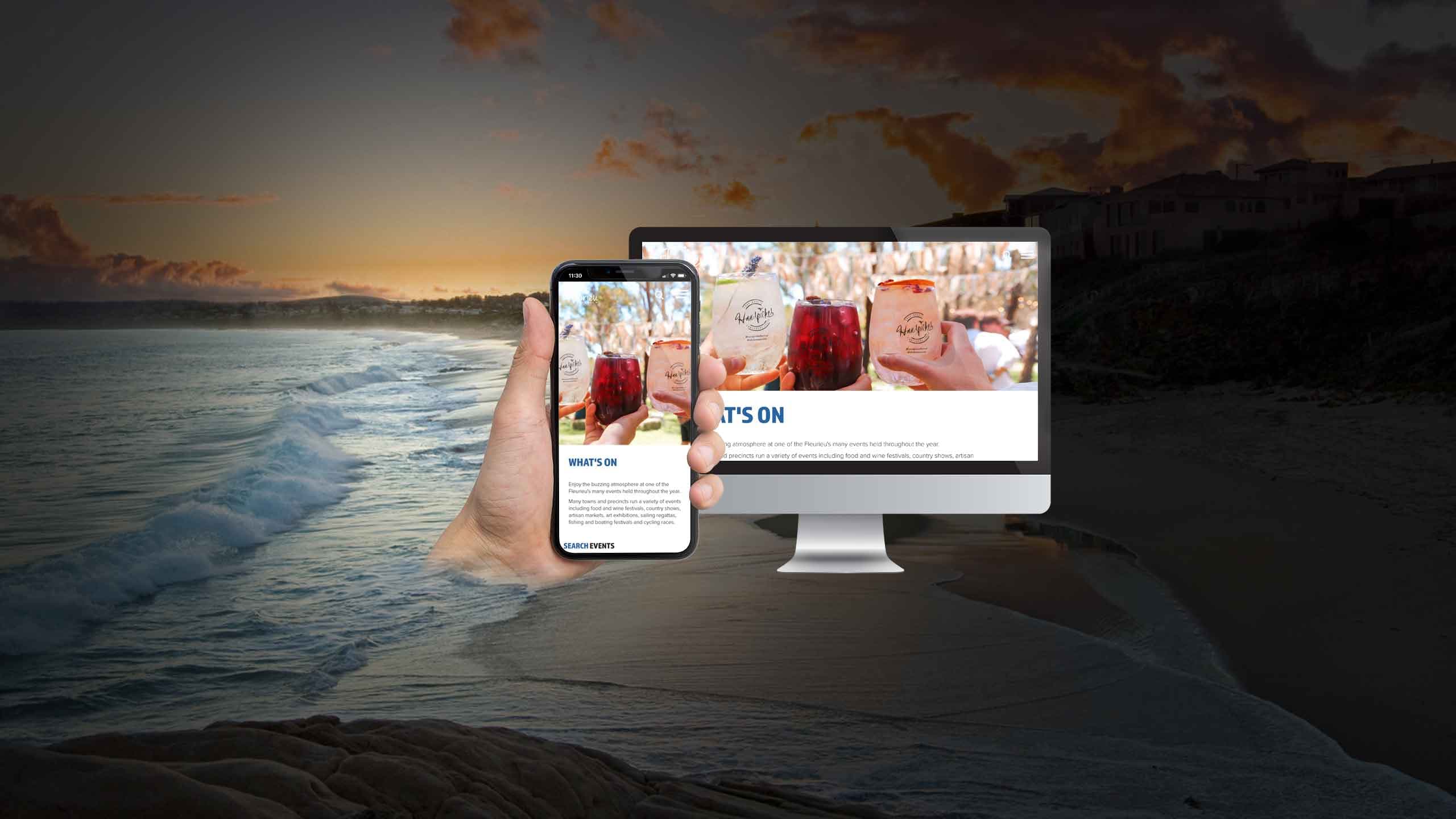 Fleurieu Peninsula Tourism website on a desktop monitor and smartphone over a coastal sunset beach
