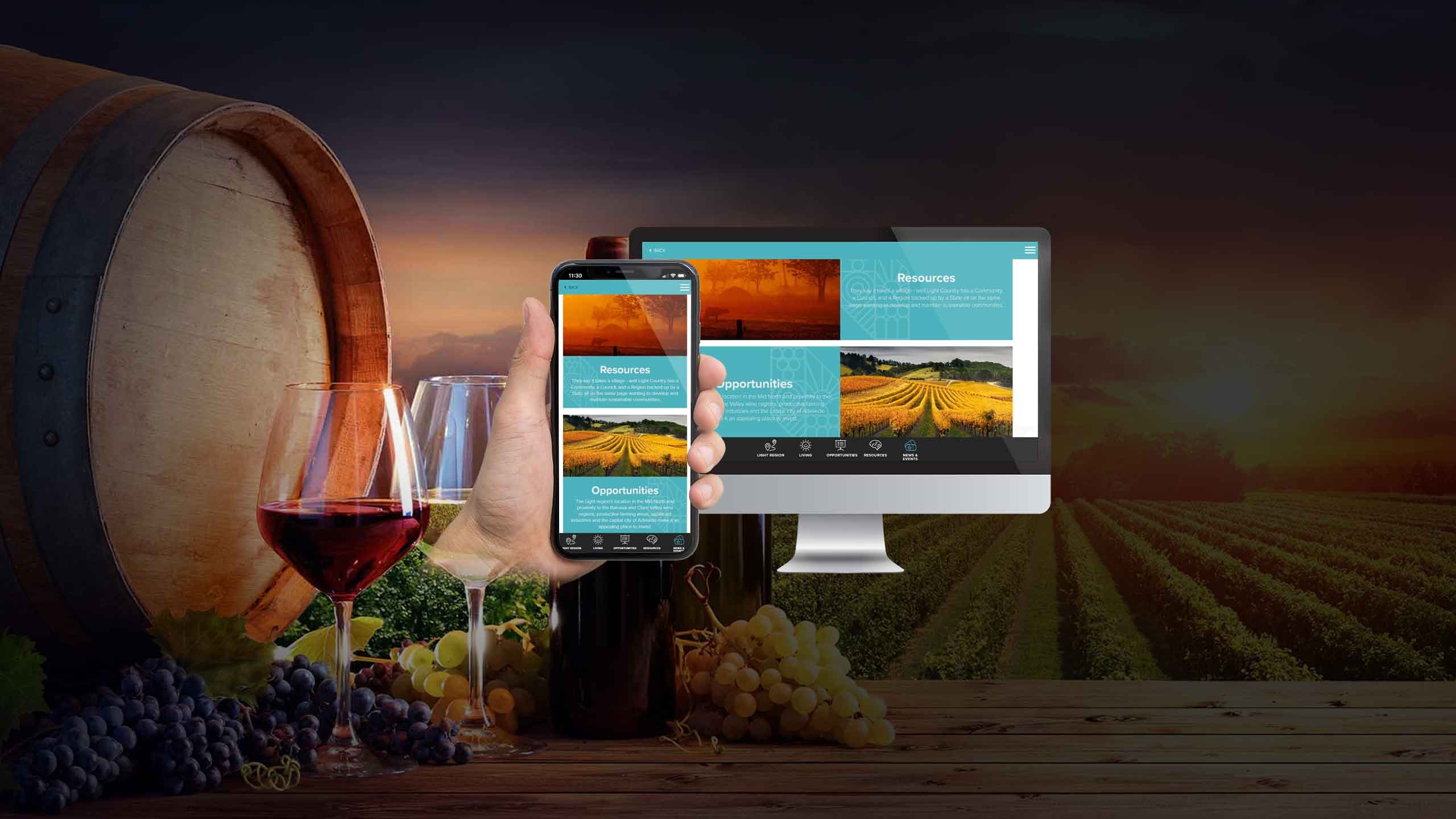Light Invest resources page shown on a desktop monitor and smartphone beside a wine barrel and grapes