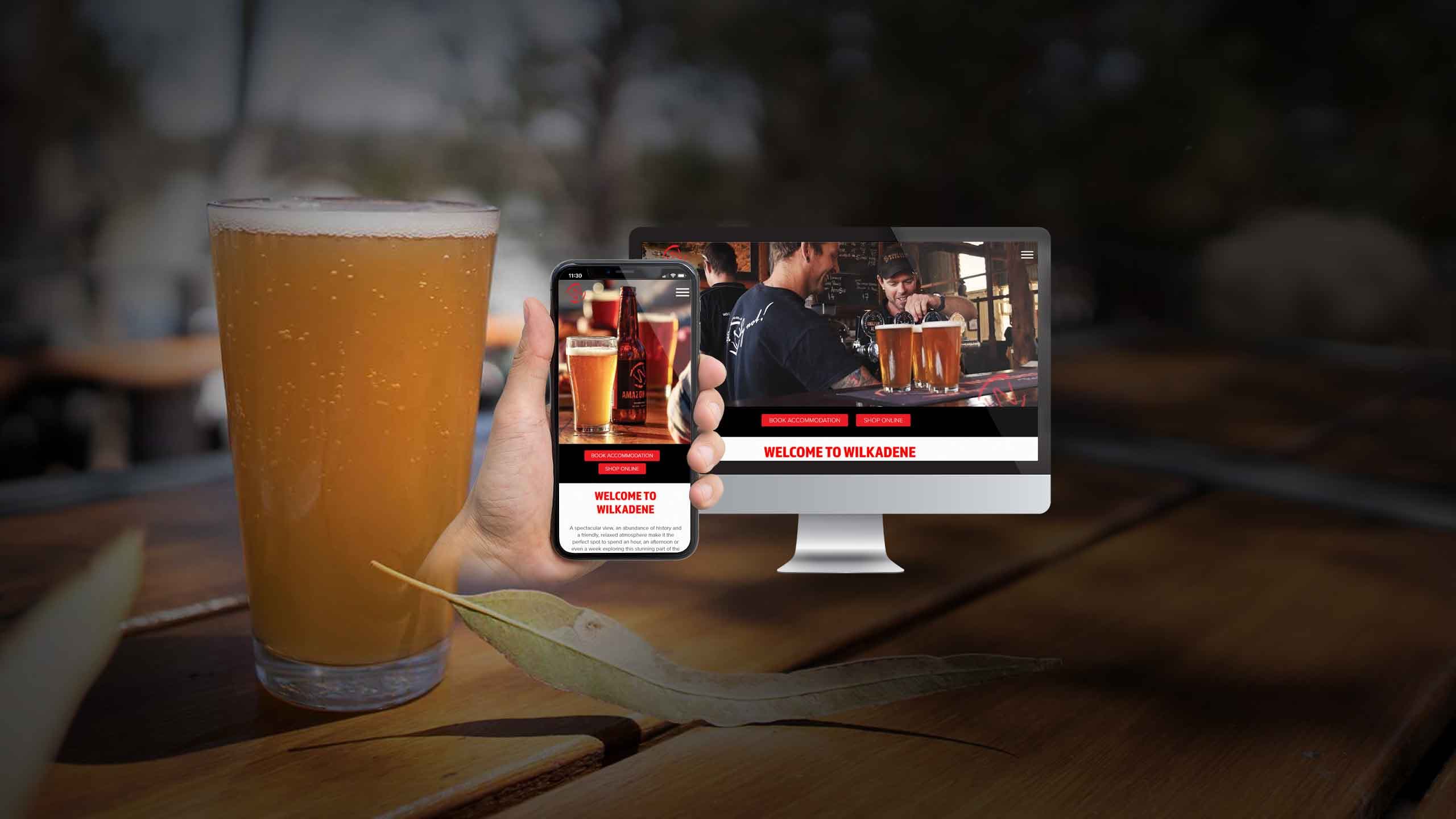 Wilkadene Above Renmark Experiences website on desktop and smartphone beside a glass of beer on a timber table