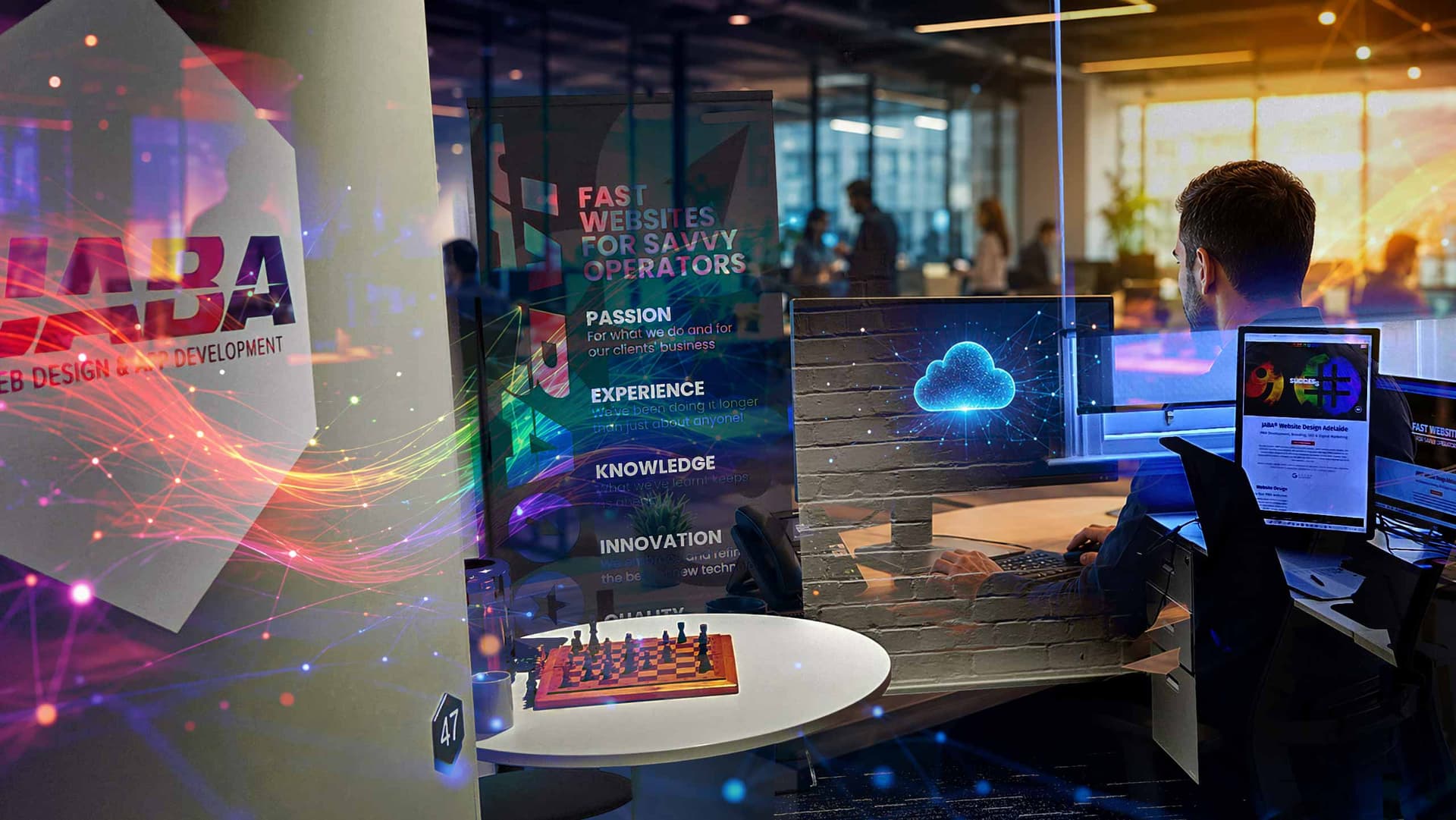 JABA office scene with branding poster, a chess board and a team member working at a computer with a cloud icon on screen