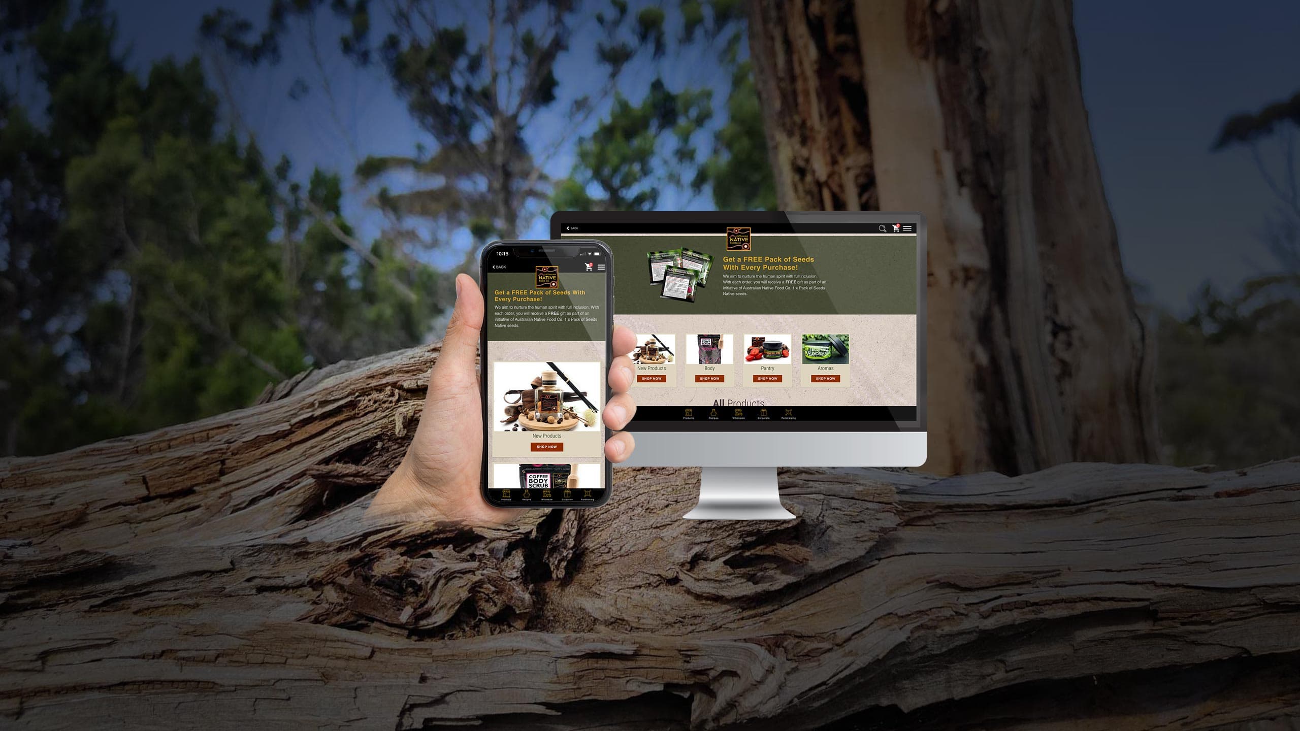 Australian Native Food Co products page displayed on a desktop monitor and smartphone over a fallen gum tree in bushland