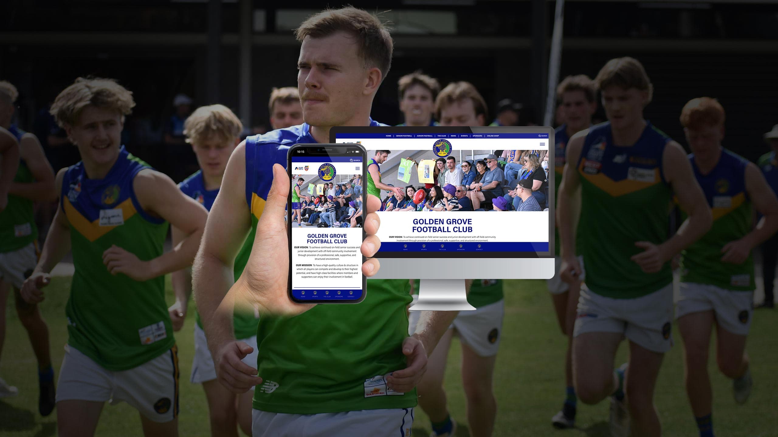 Golden Grove Football Club players running onto the field behind a monitor and phone showing the club's new website homepage