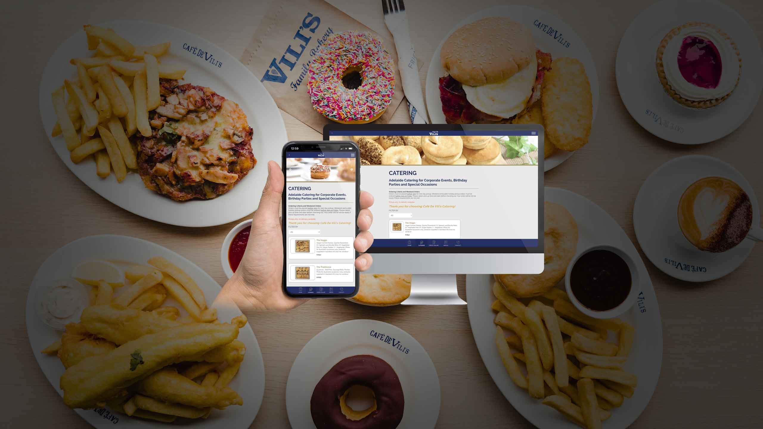Cafe De Vili's Catering page displayed on a desktop monitor and smartphone over a spread of cafe food