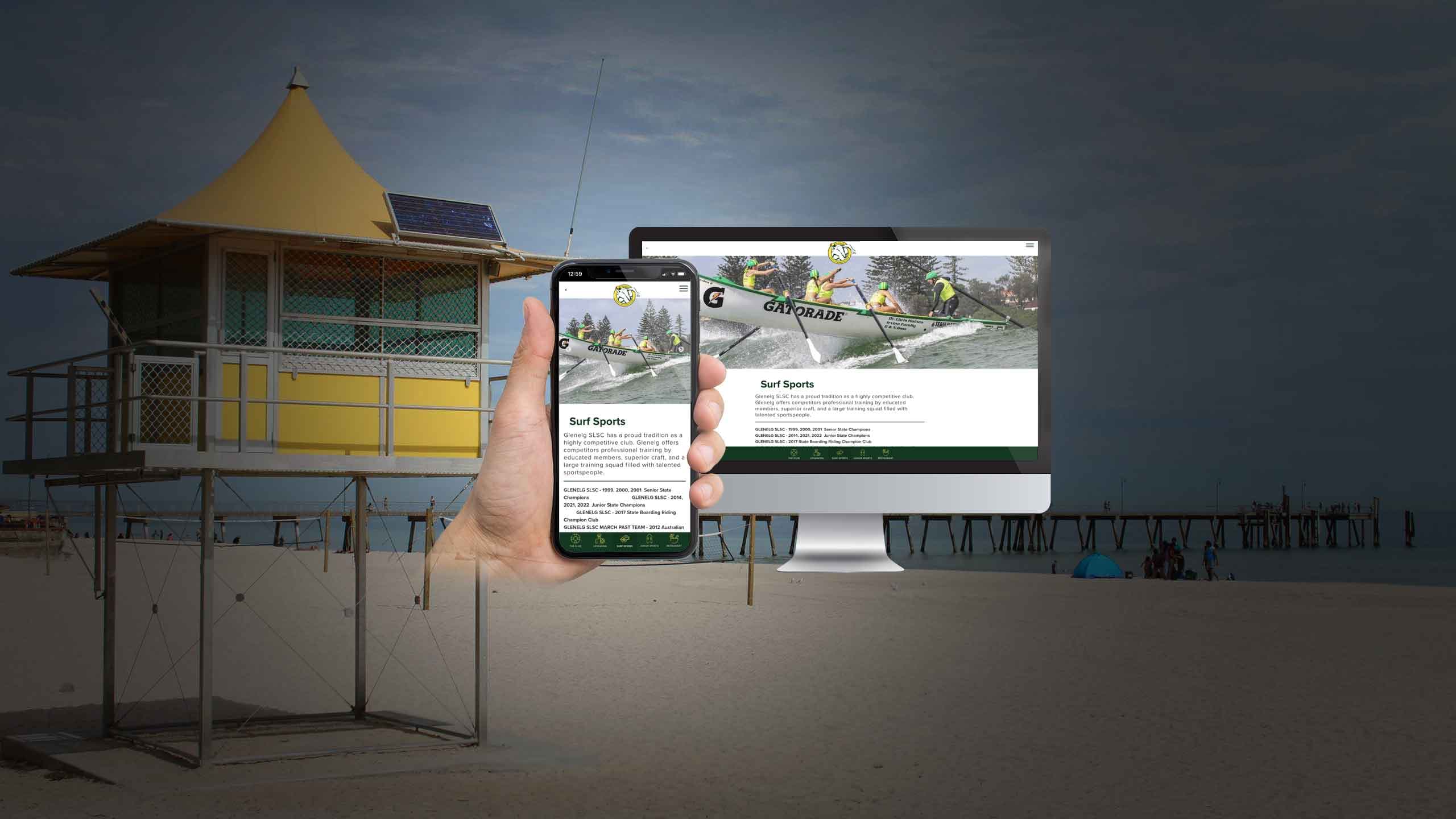 Glenelg lifeguard tower on the beach with the Glenelg SLSC Surf Sports page shown on a smartphone and monitor