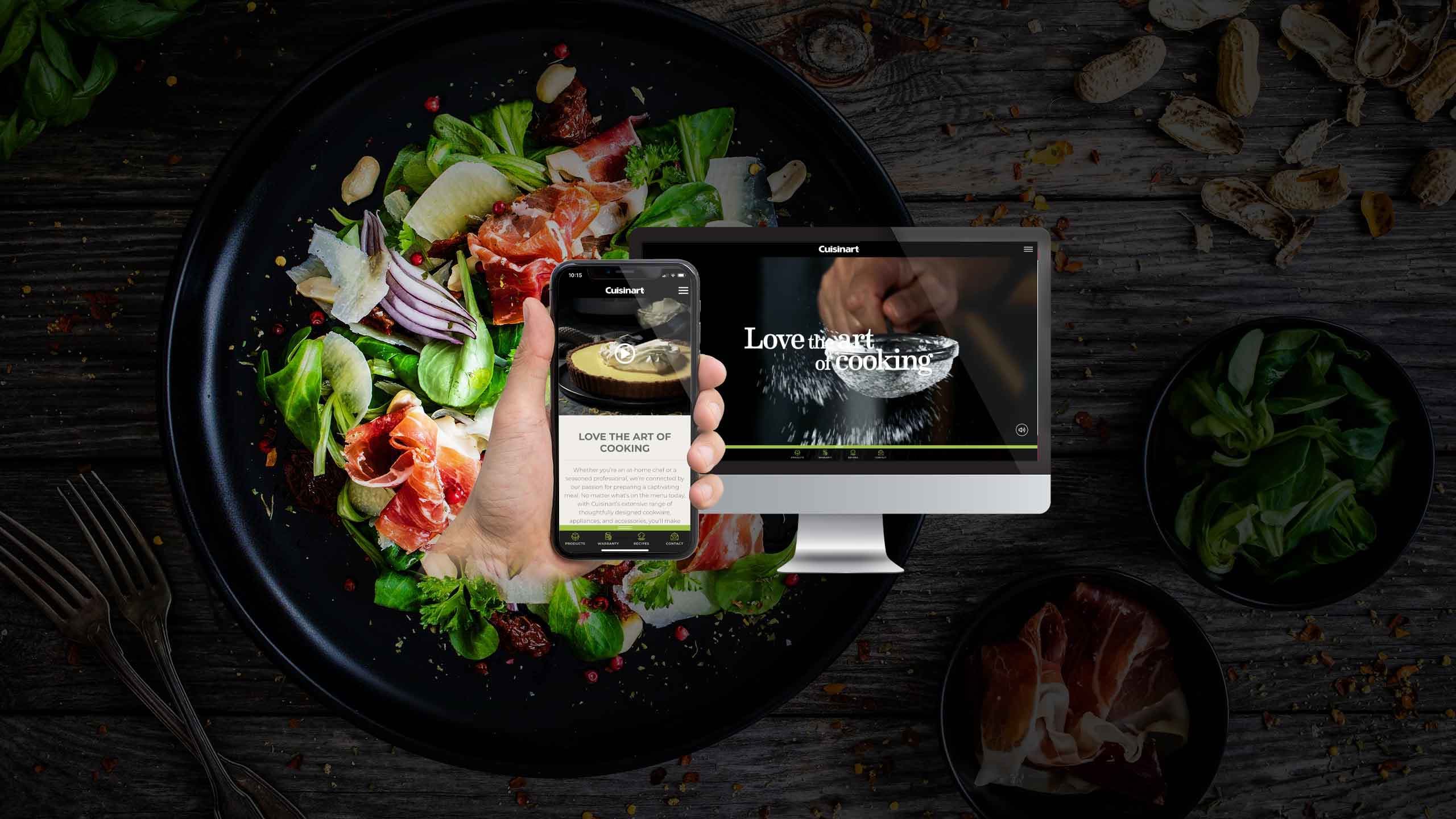 Cuisinart website displayed on a desktop monitor and smartphone over a gourmet salad plate