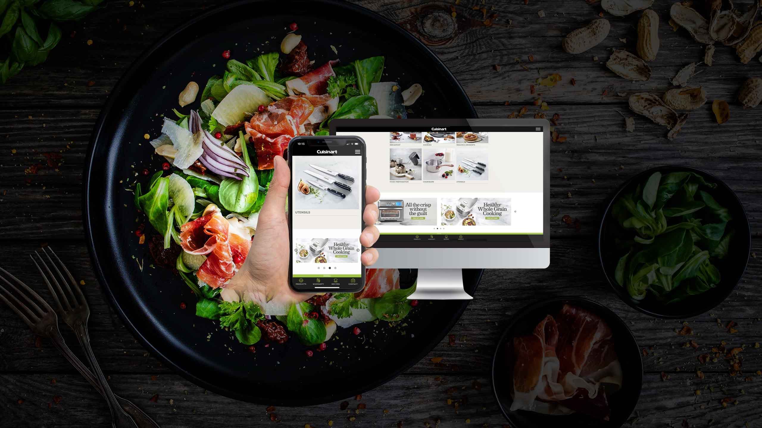 Cuisinart website product range page displayed on a desktop monitor and smartphone over a gourmet salad plate