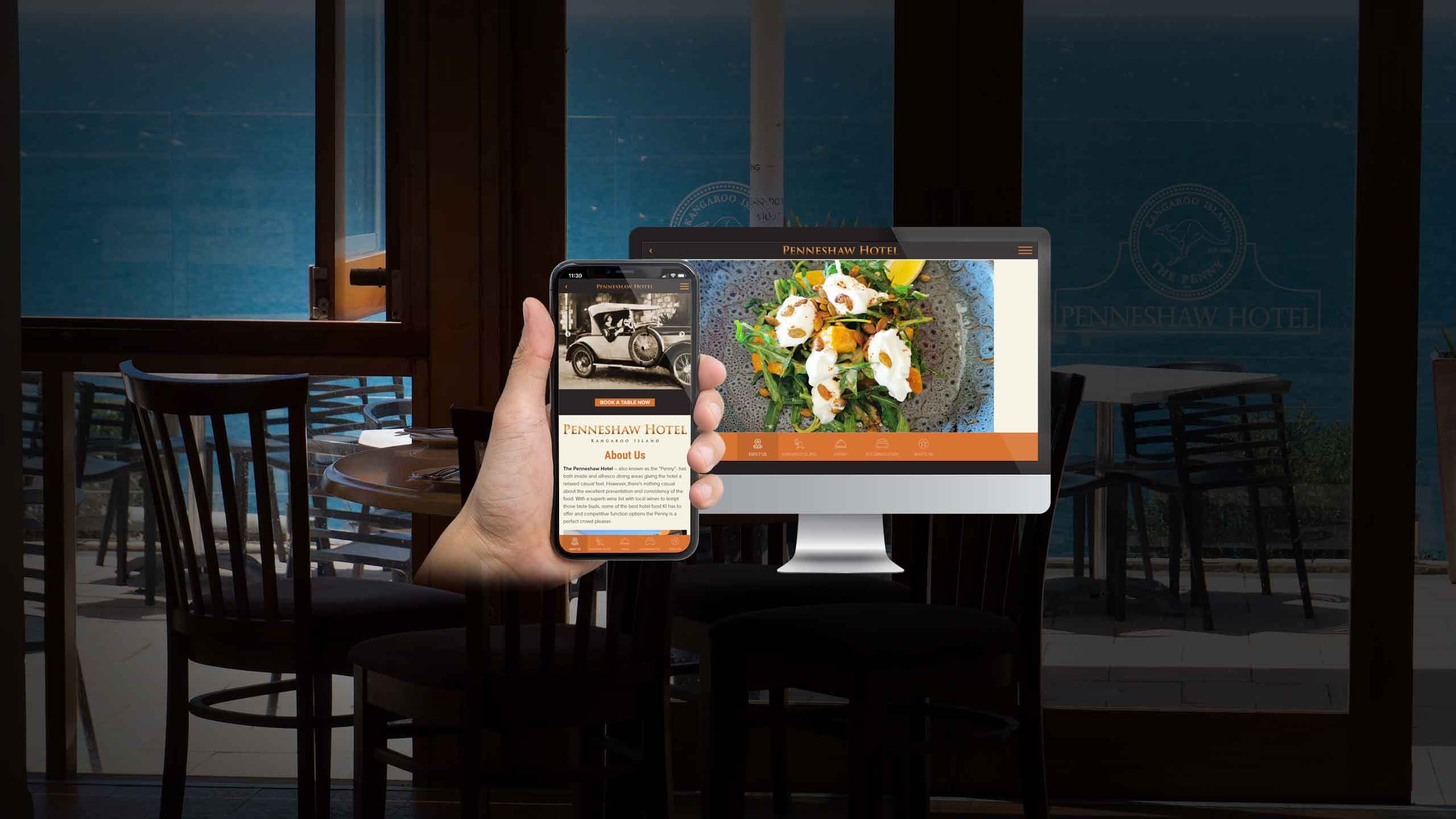 Penneshaw Hotel website About Us page displayed on a desktop monitor and smartphone within the venue's dining terrace