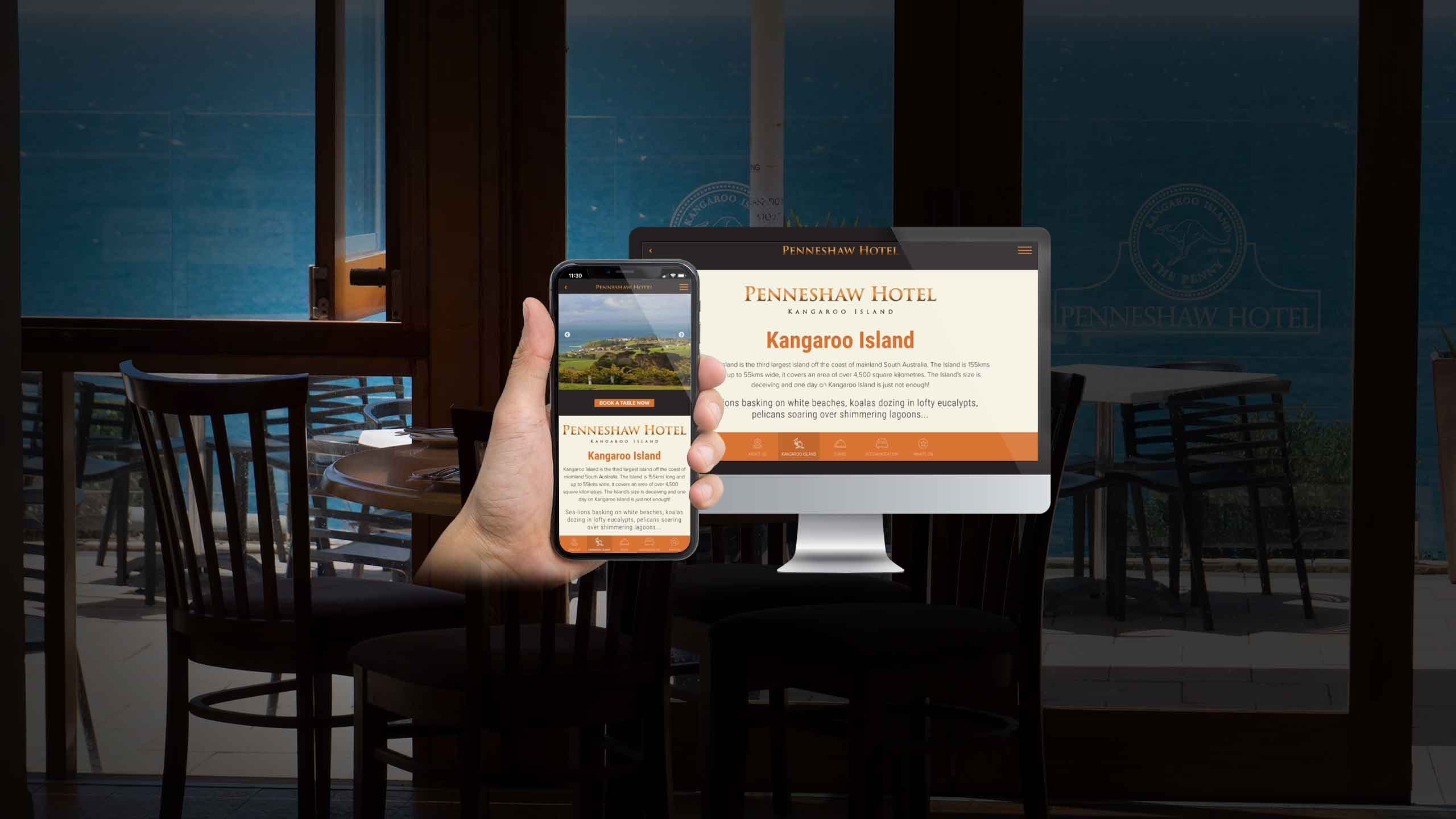 Penneshaw Hotel website Kangaroo Island page displayed on a desktop monitor and smartphone within the venue's dining terrace