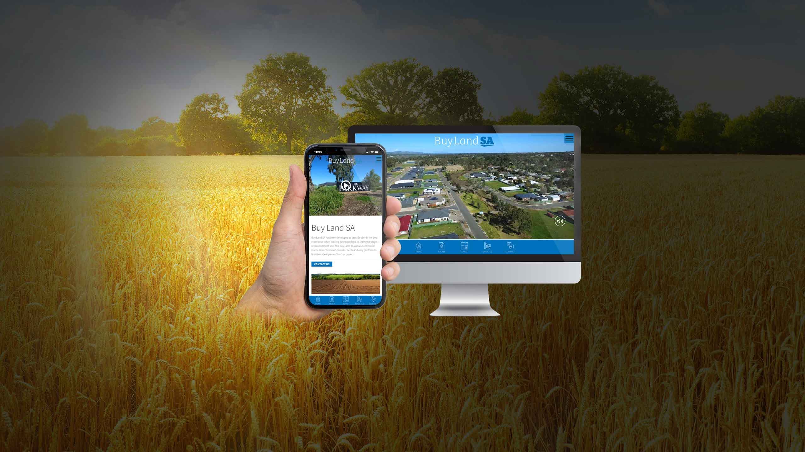 Buy Land SA website homepage displayed on a desktop monitor and smartphone over a wheat field at sunset