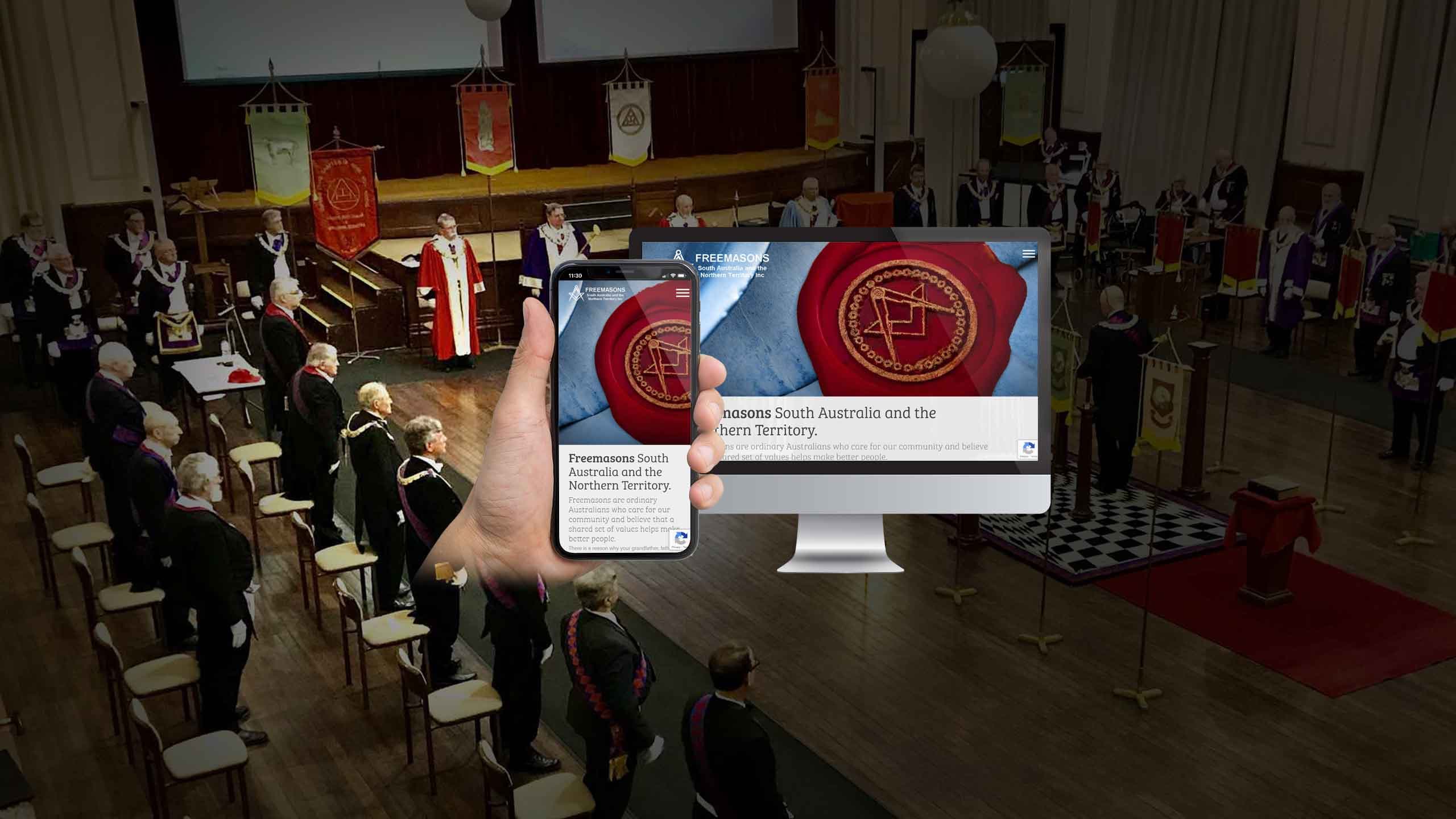 Freemasons website mockup displayed over a Masonic lodge ceremony hall
